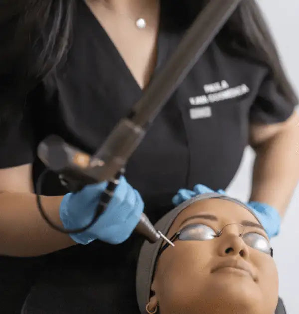 Person receiving a cosmetic procedure with medical equipment and gloves on.