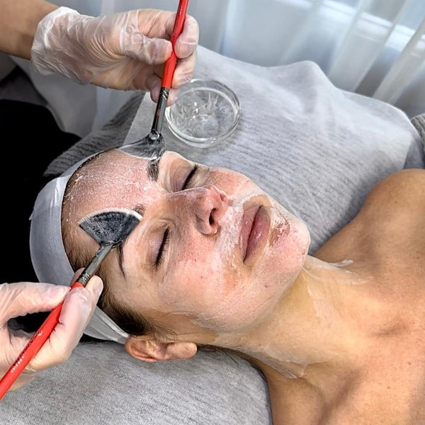 Person receiving a facial treatment with a mask applied to their face.